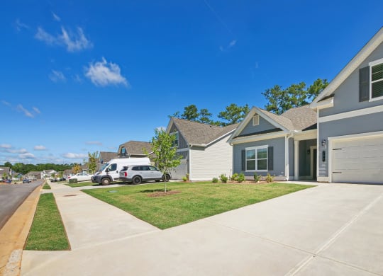 a house with a driveway and a lawn in front of it