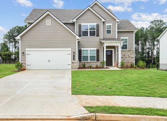 a house with a white garage door in front of a lawn