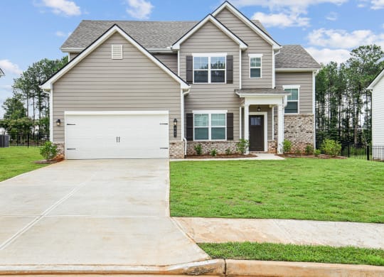 a house with a white garage door in front of a lawn