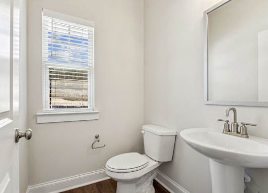 a bathroom with a toilet and a sink and a window