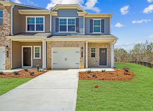 a house with a white garage door and a lawn