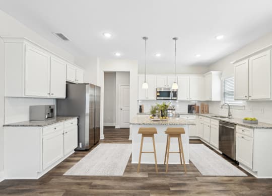 a large kitchen with white cabinets and stainless steel appliances