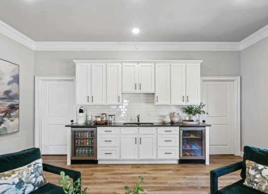 a kitchen with white cabinets and a counter top with a sink