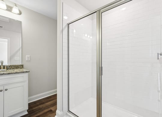 a white bathroom with a shower and a sink