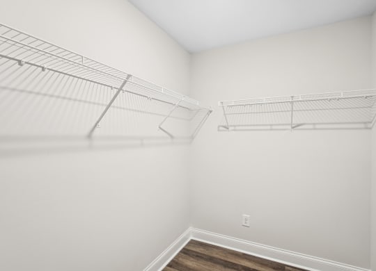 an empty bedroom with white walls and a closet with metal shelves