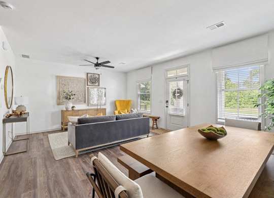 Living room with large couch, accent chairs, and windows.