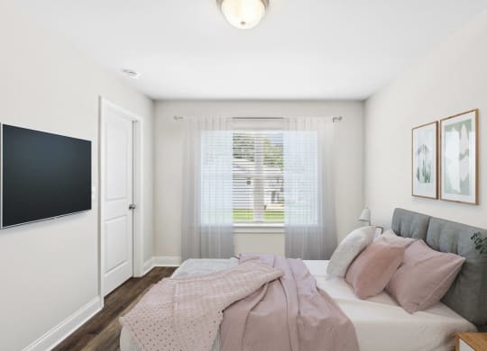 a bedroom with a bed and a tv on the wall