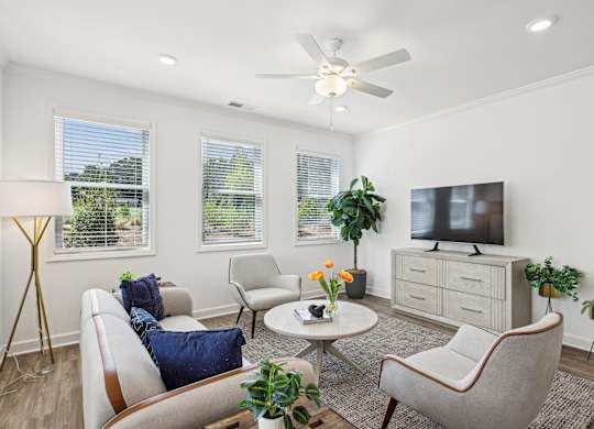 a living room with couches and chairs and a tv