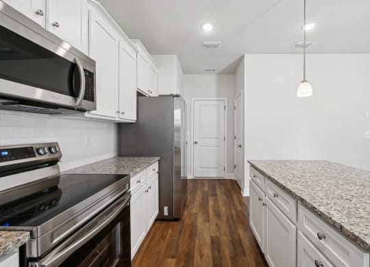 4-bedroom single family home with spacious kitchen. Open-floor plan concept with kitchen island, ample storage and bar seating.