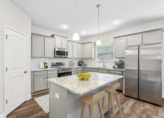 a kitchen with stainless steel appliances and a marble counter top