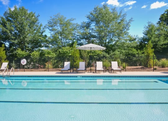 a swimming pool with chairs and an umbrella