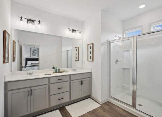 Primary bathroom with double vanity, and walk-in shower.