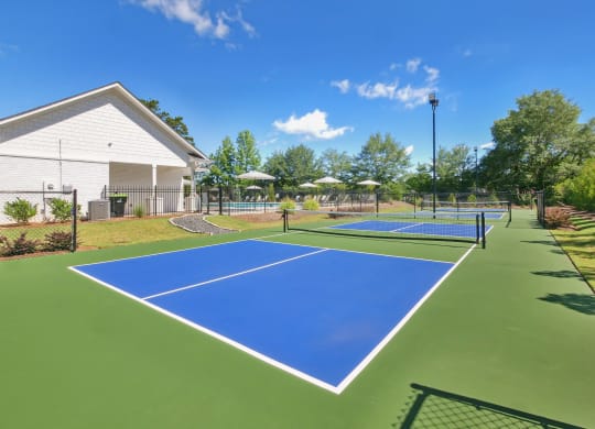 two tennis courts with umbrellas at the enclave at woodbury