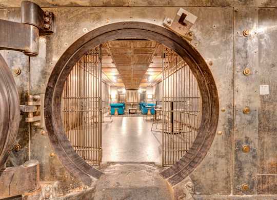 a large metal door in a room with tables and chairs at Metro67, Memphis