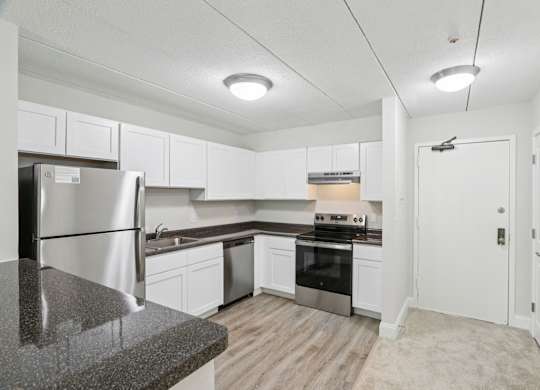 A kitchen with white cabinets and stainless steel appliances.