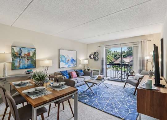 A well-lit living room with a dining table set for two.