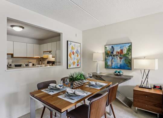 A dining room with a wooden table set for two.