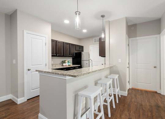 A kitchen with white cabinets and a granite countertop.
