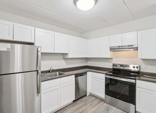 A kitchen with white cabinets and stainless steel appliances.