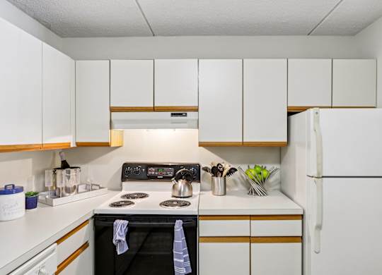 A kitchen with a black stove top oven and white cabinets.