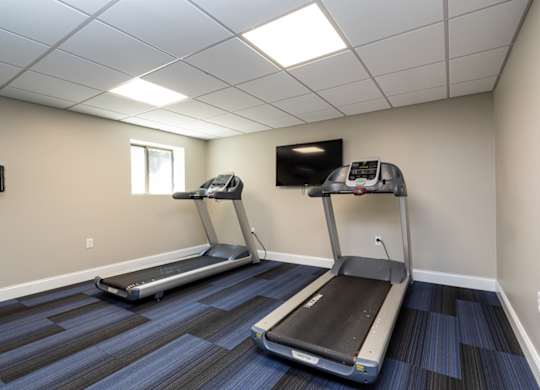 Quincy Commons gym with treadmills and a tv
