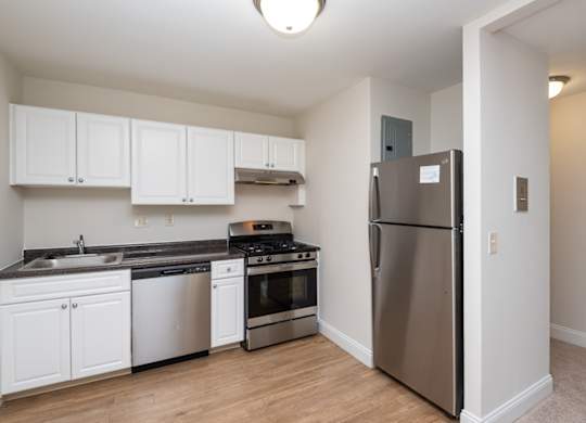 Quincy commons kitchen with white finishes, high quality flooring, and stainless steel appliances