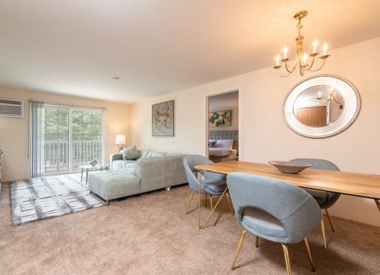 Two bedroom common area living room with balcony and dining space with plush carpeting