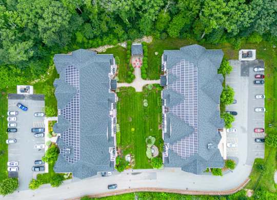 a birds eye view of the roofs of two buildings and a parking lot