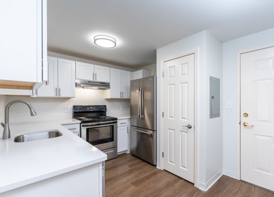 a renovated kitchen with white cabinets and stainless steel appliances