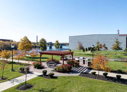 The courtyard with picnic area, fireplace, grills, boche court, and riverfront views