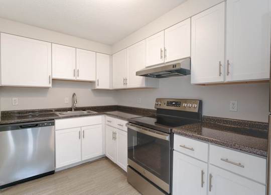 a kitchen with white cabinets and stainless steel appliances