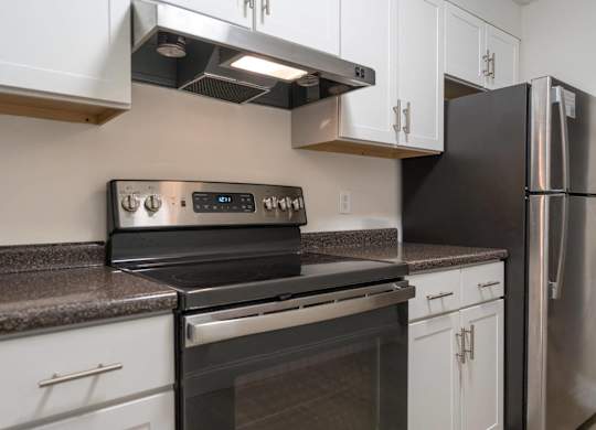 a kitchen with stainless steel appliances and white cabinets