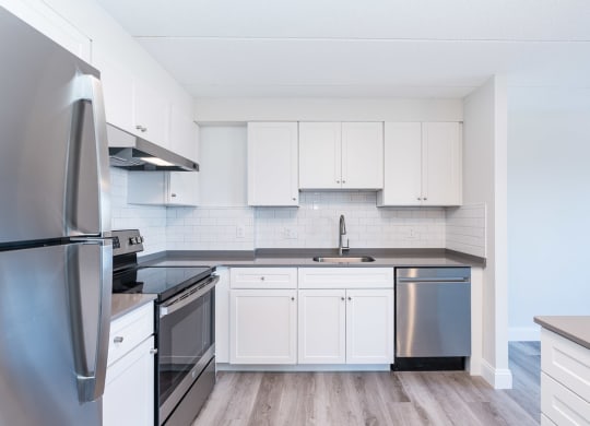 a kitchen with white cabinets and stainless steel appliances