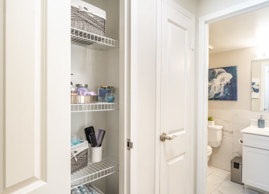 a small bathroom with white cabinets and a white door