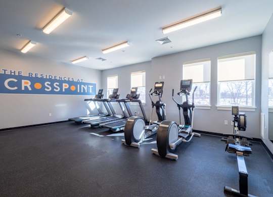 A cardio area in the fitness center equipped with treadmills and rowing machines.