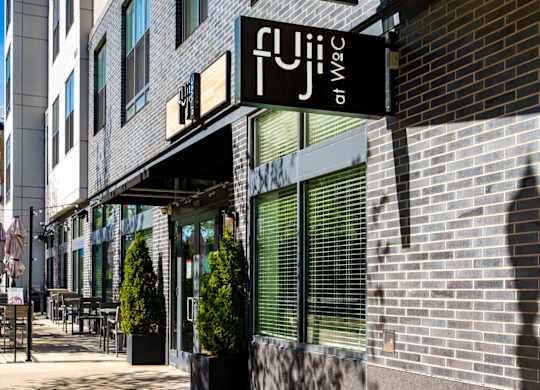 A black and white sign that says Fuji on WoC on a building in Quincy, MA.