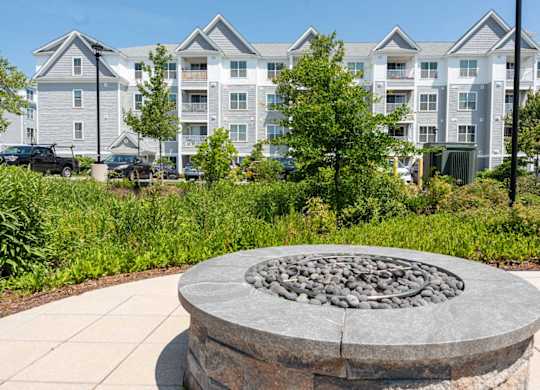 a stone fire pit in front of an apartment building