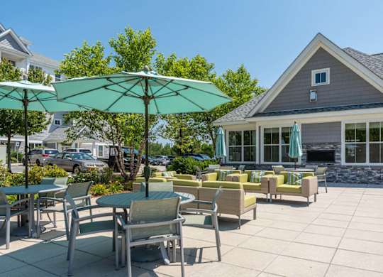 a patio with tables chairs and umbrellas outside of a building