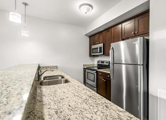 Ashland woods apartment kitchen with stainless steel appliances, stove, microwave, oven, and granite counters