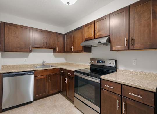 A kitchen with wooden cabinets and stainless steel appliances.
