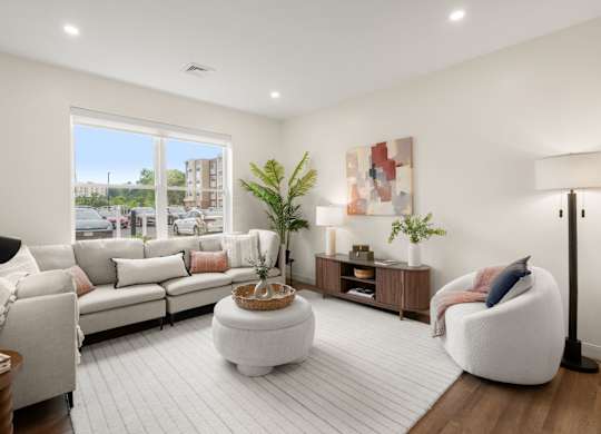 A modern living room with a large window overlooking a street.
