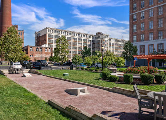 A park with a brick building in the background.