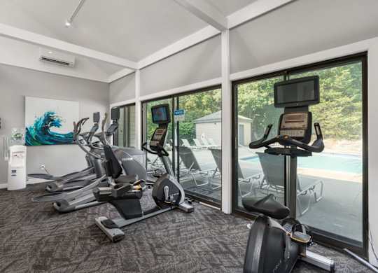 A room with a treadmill, exercise bike, and other equipment.