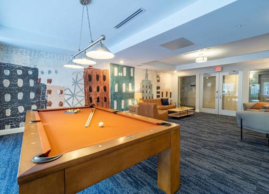 A stylish billiards room with a pool table and comfortable seating in the lounge