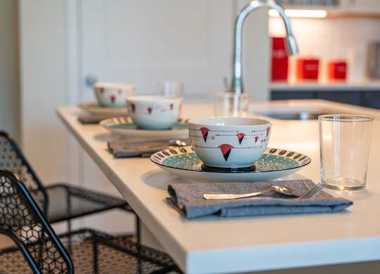 Mastlight apartment kitchen counter with a bowl, a glass, and a plate on it.