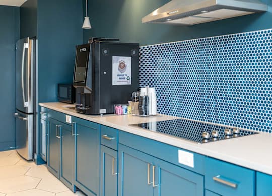 A kitchen with blue cabinets and a black fridge at the Mastlight.