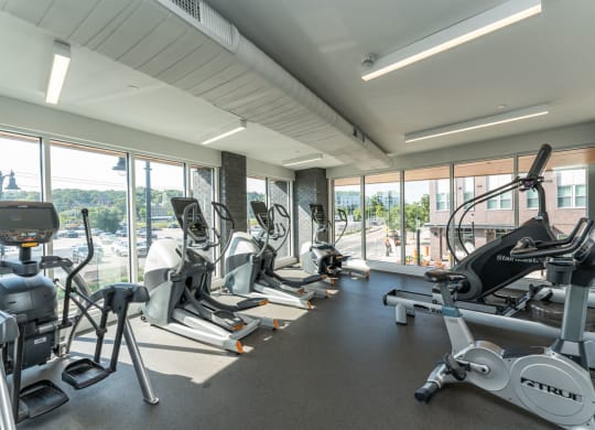 a gym with various exercise equipment and windows