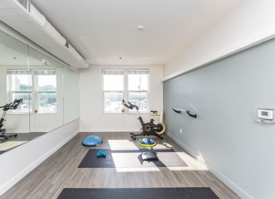 a workout room with yoga equipment and mirrors in a home gym
