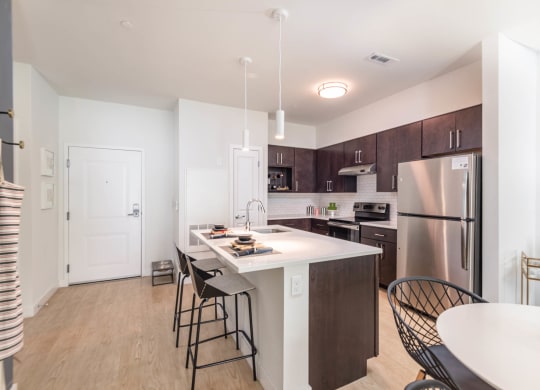 a kitchen with a large center island with a breakfast bar