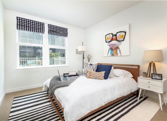 a bedroom with a bed and two windows